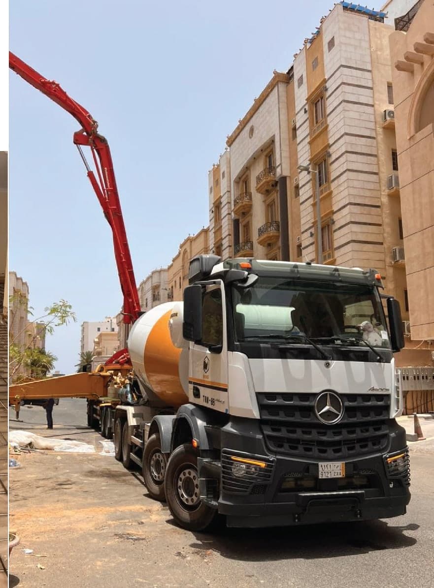 مضخة خرسانة ومركبة خلط في موقع عمل بجوار مبنى