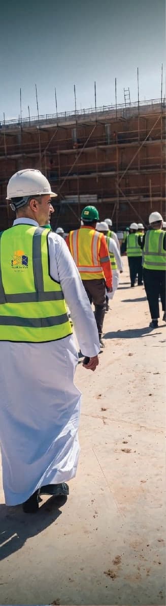 مهندسون يرتدون سترات السلامة أثناء جولة ميدانية في موقع إنشائي